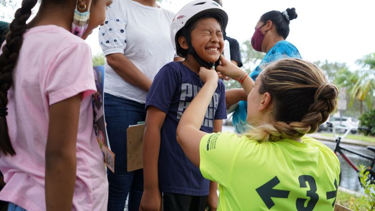 a woman puts a helmet on a child